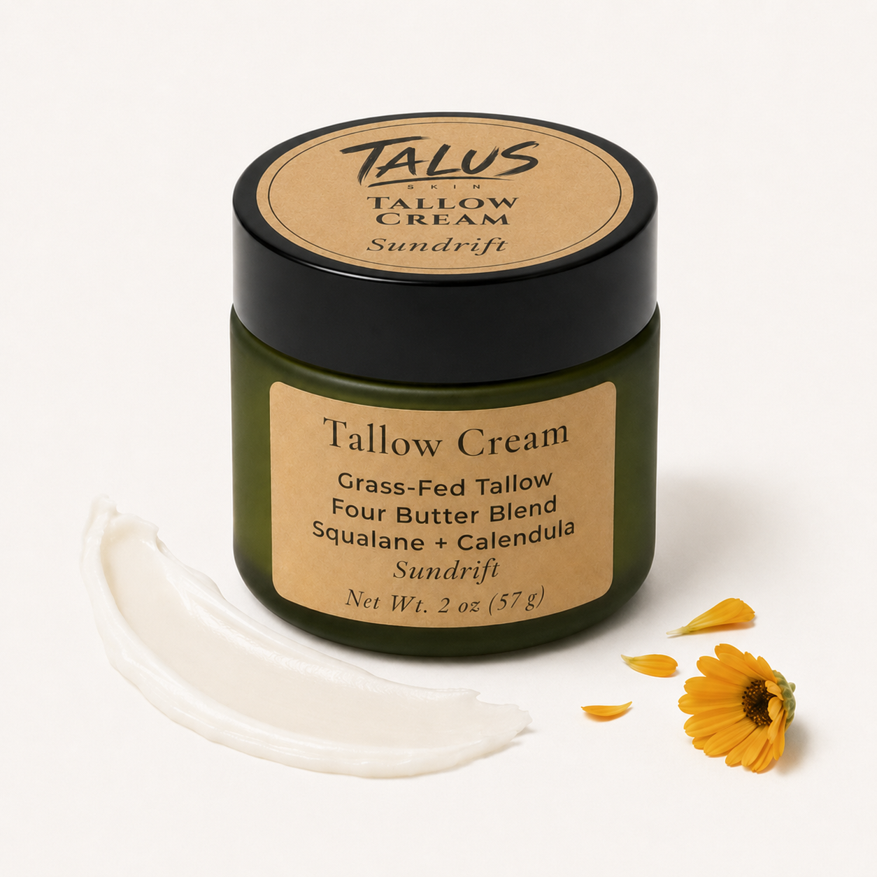 A jar of Cadia Skincare Sundrift Tallow Cream with a black lid and beige label, shown on a white background with a smear of white cream and yellow flower petals.